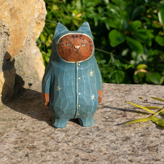 Hand-carved wooden figurine of a tabby cat in starry pajamas, whimsical decor for cat lovers.