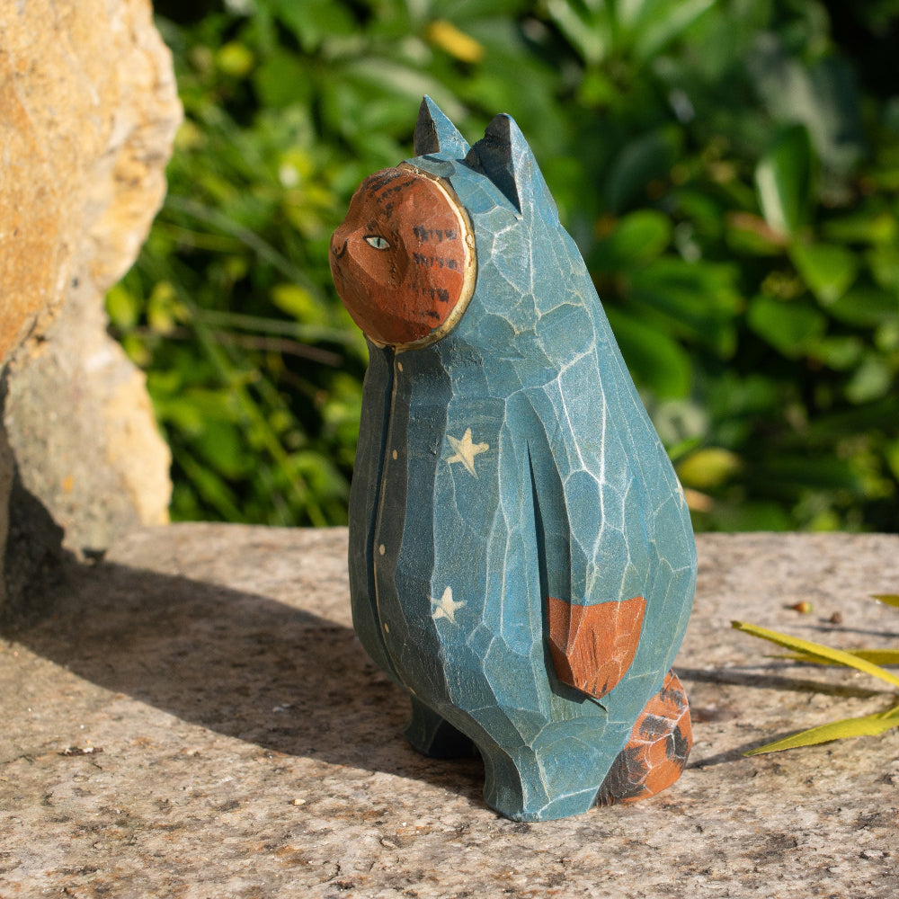 Hand-carved wooden figurine of a tabby cat in starry pajamas, whimsical decor for cat lovers.