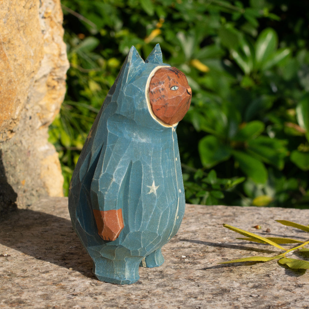 Hand-carved wooden figurine of a tabby cat in starry pajamas, whimsical decor for cat lovers.