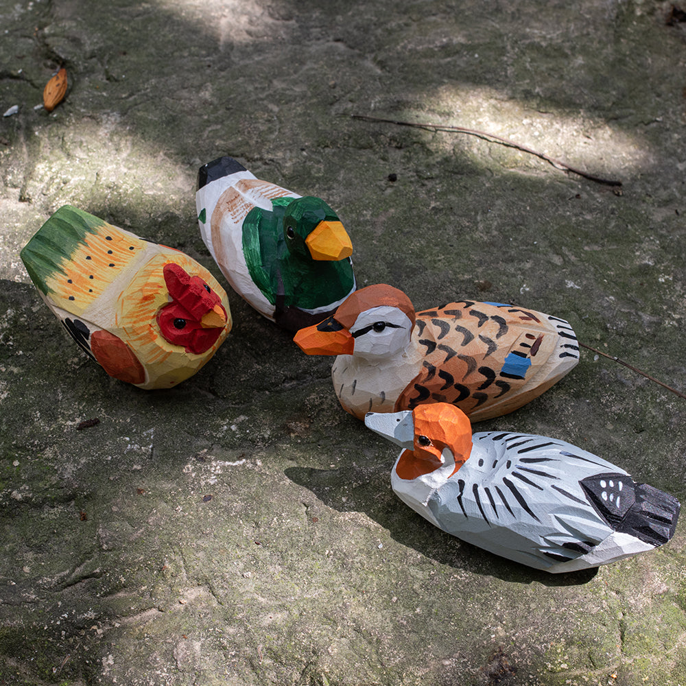 A set of hand-carved wooden bird figurines, including a barnyard hen, mallard duck, spotbilled duck, and redhead duck. 