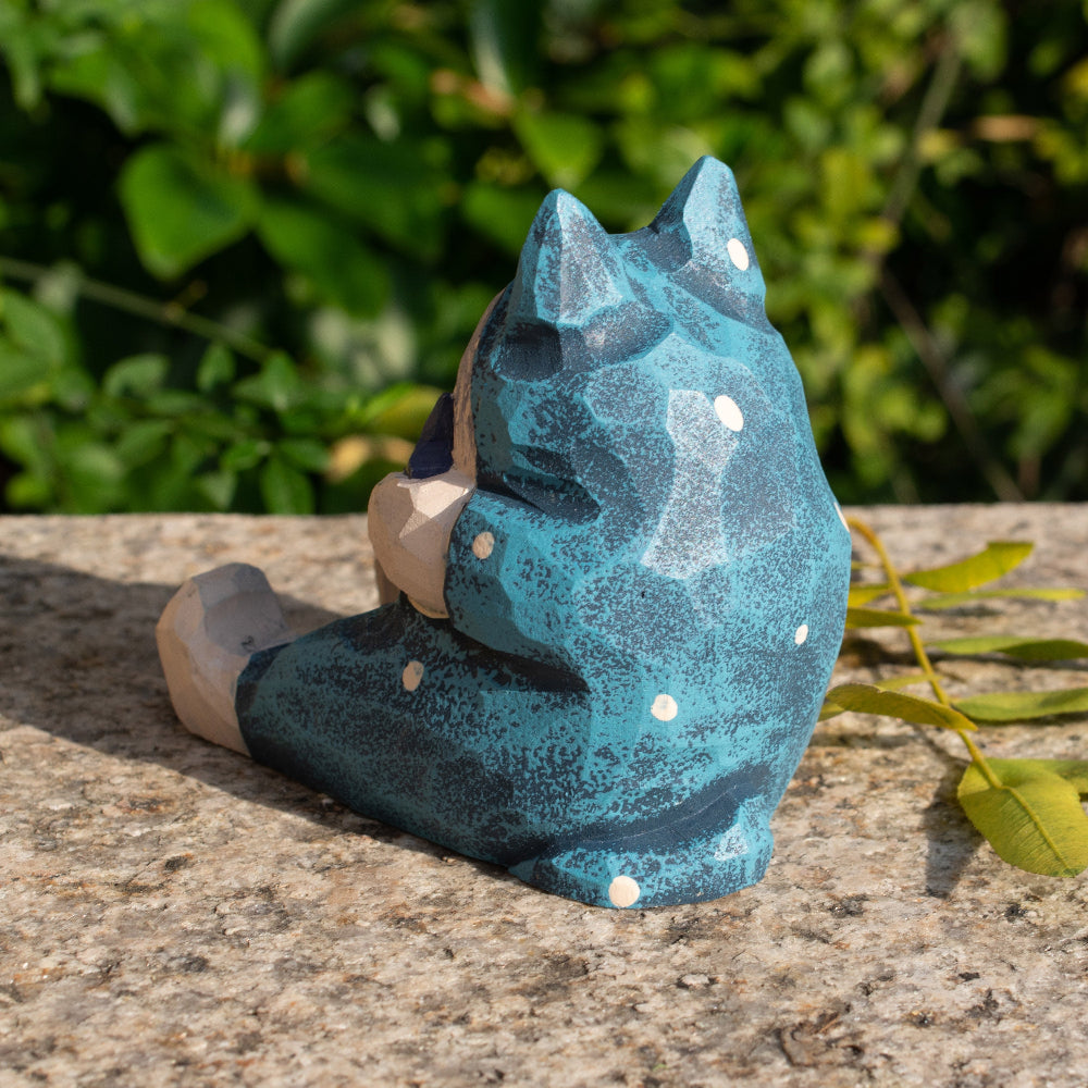 Hand-carved wooden cat figurine phone stand holding a fish, a functional decor piece for cat lovers.