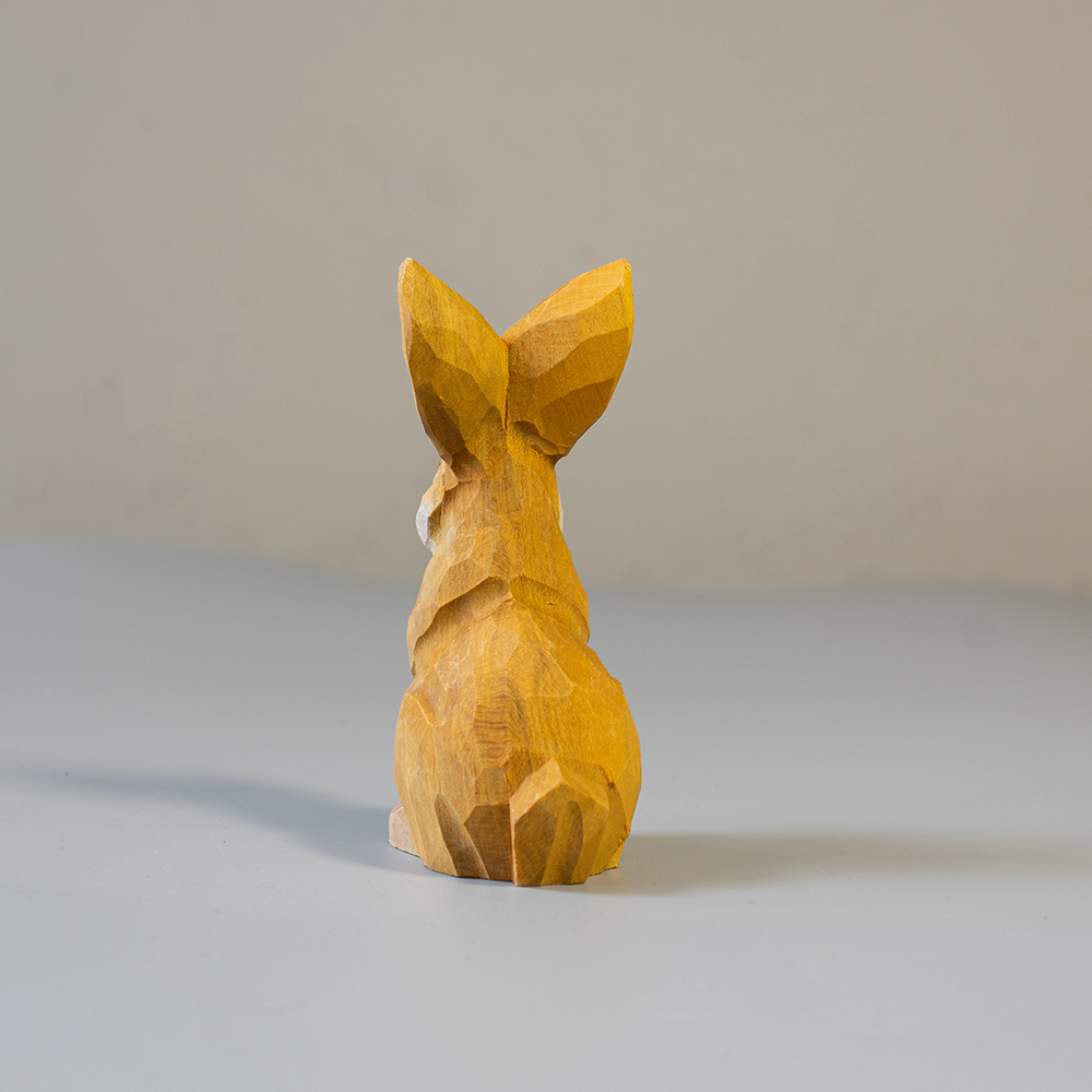 Wooden rabbit figurine on a neutral background