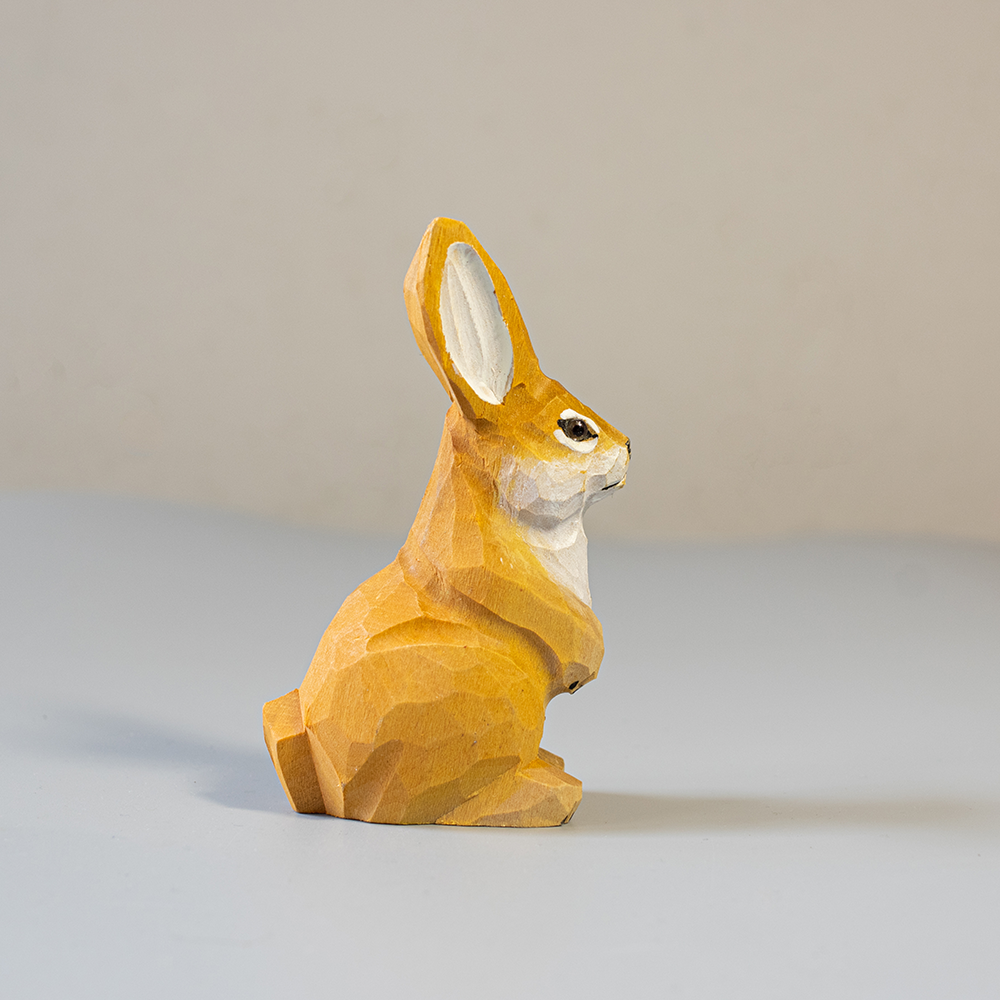 Wooden rabbit figurine on a light gray background